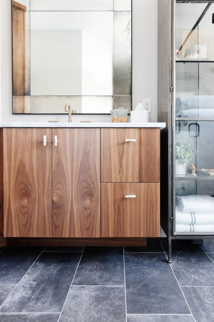 Carrara marble countertops and an architectural wood panel from The Tile Shop.