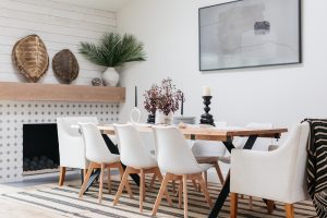 Black, white, and tan dining area with added fireplace and turtle shell décor in modern beach home