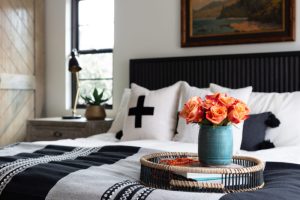 Black and white home bedroom with coastal accents and tan sliding farmhouse doors