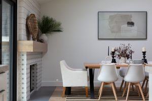 Dining room in black and white home with tan elements and fireplace