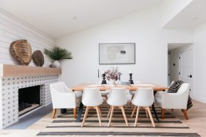 Black, white, and tan dining area with added fireplace and turtle shell décor in modern beach home