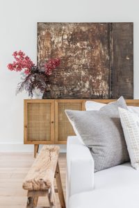 Brown abstract painting and rattan dresser in living room