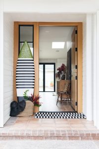 Front door view of black and tan home on the beach