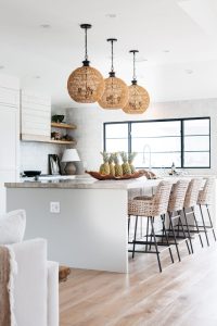 White kitchen with oak floors and black hardware in modern beach home