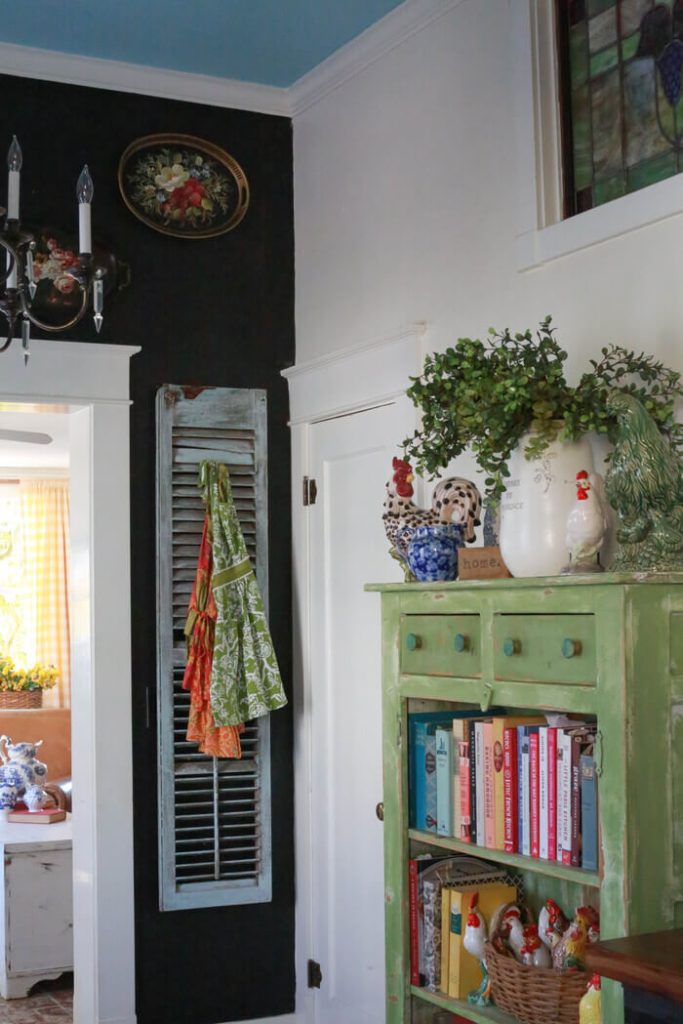 Green pine cabinet next to a black chalkboard wall