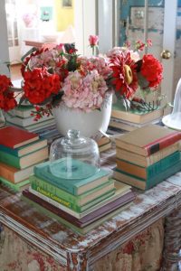 Stacks of gardening books and a flower pot on a vintage table