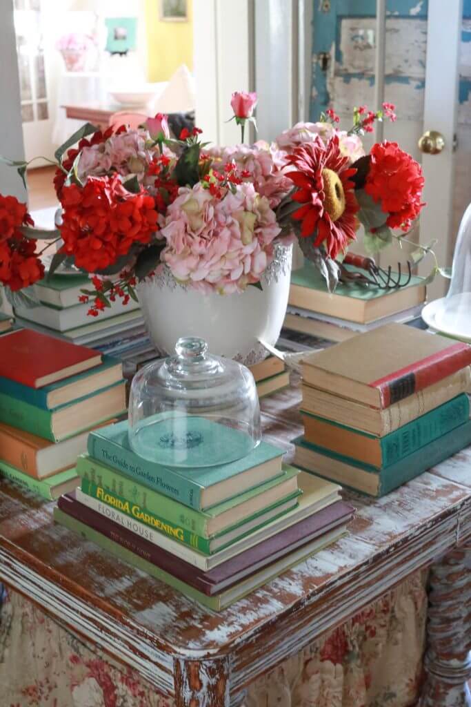 Stacks of gardening books and a flower pot on a vintage table