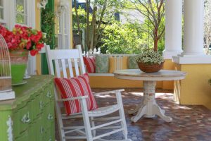 Rocking chair, table, and buffet table on a front porch