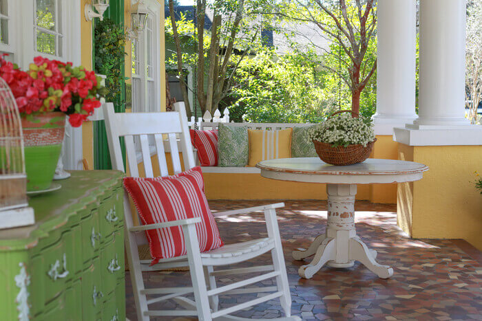 Rocking chair, table, and buffet table on a front porch