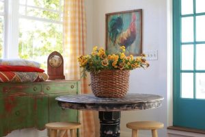 A basket of yellow flowers on a black, distressed table