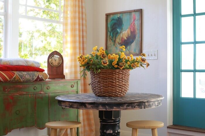A basket of yellow flowers on a black, distressed table
