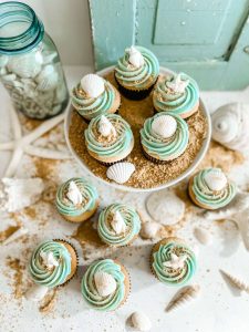 Beach inspired cupcakes decorated with brown sugar sand and sea shells