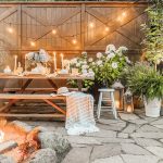 Outdoor patio with picnic table decorated with candles and string lights