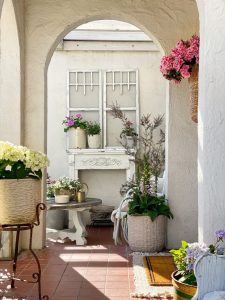 Plants and flowers on a cottage's front porch.