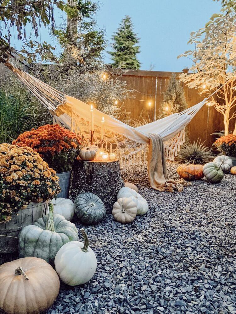 Backyard area with a hammock and candles, decorated for fall
