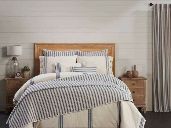 blue and white stripped bedding on bed with oak headboard with coordinating curtains