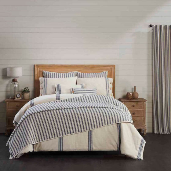 blue and white stripped bedding on bed with oak headboard with coordinating curtains