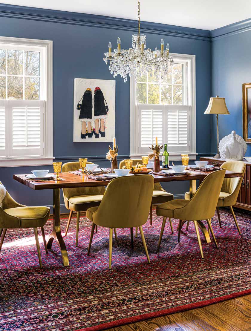 blue dining room with chandelier and contemporary art