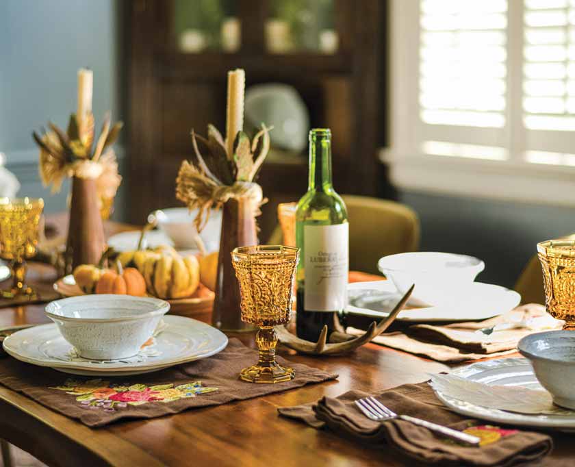 tablescape with vintage amber glasses and floral embroidered placemats and tapers