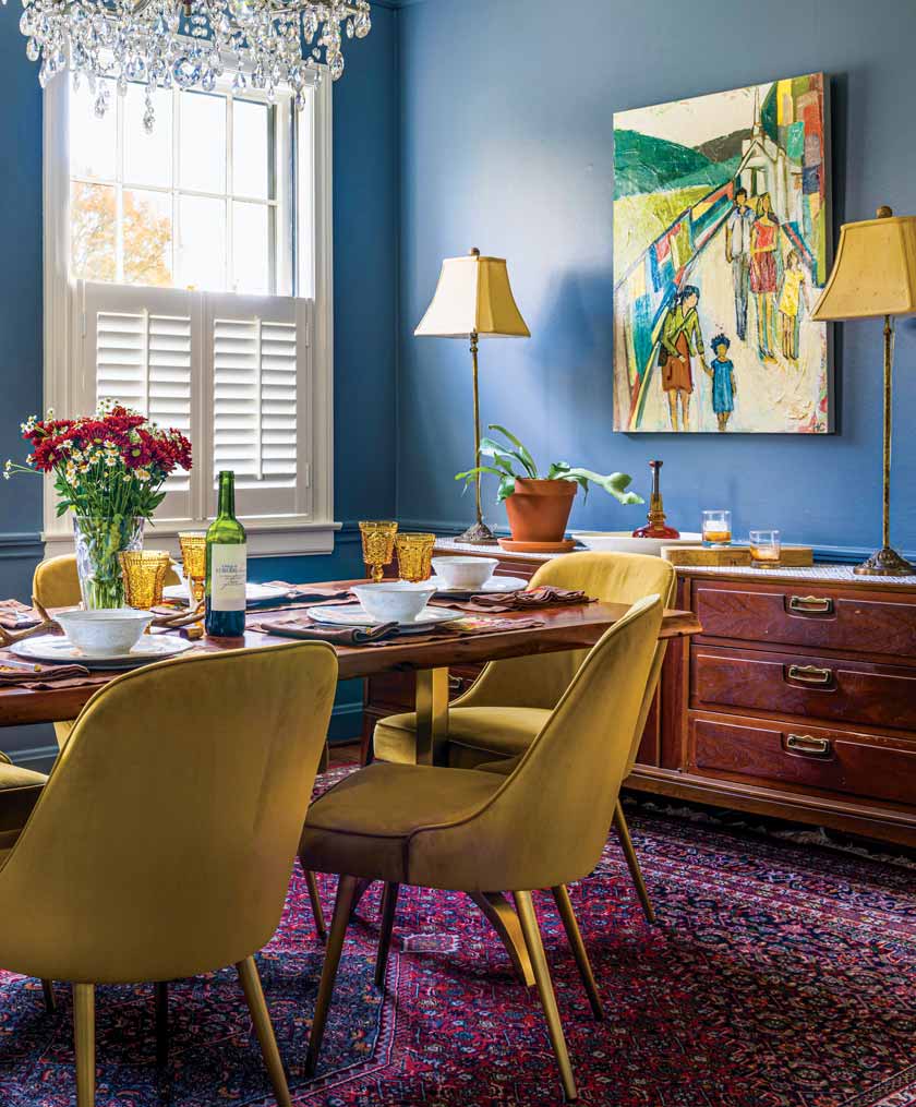 blue dining room with traditional rug and modern art and chandelier