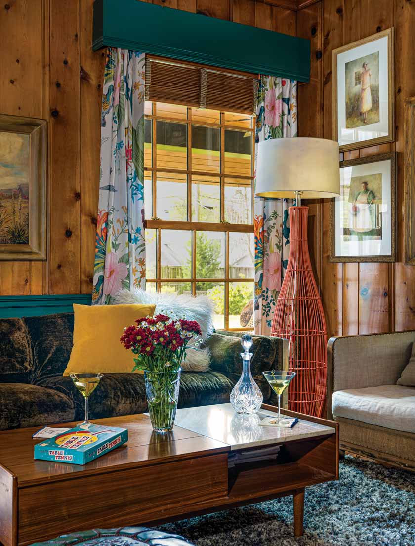 wood paneled room with floral patterned drapes and framed art