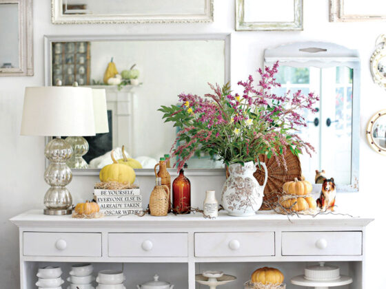 sideboard styled with white dish ware and pumpkins