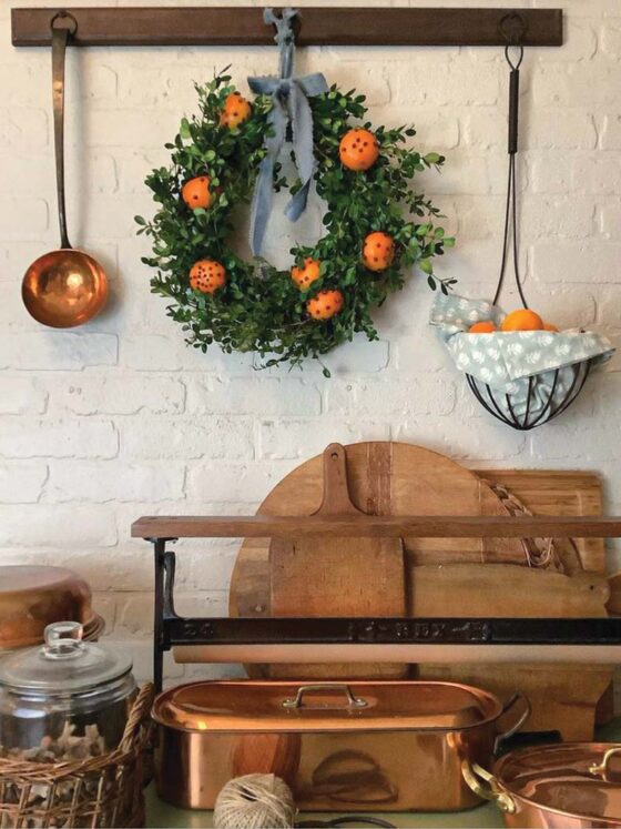 homemade boxwood wreath with oranges and cloves in cottage pantry