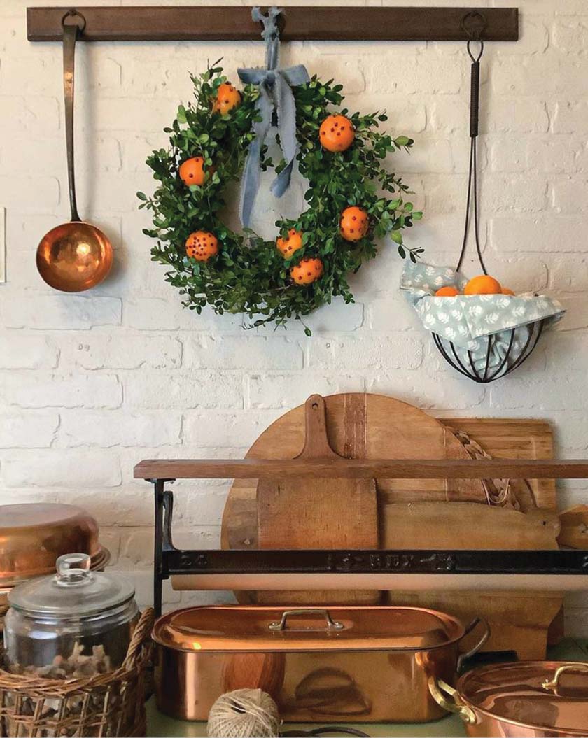 homemade boxwood wreath with oranges and cloves in cottage pantry