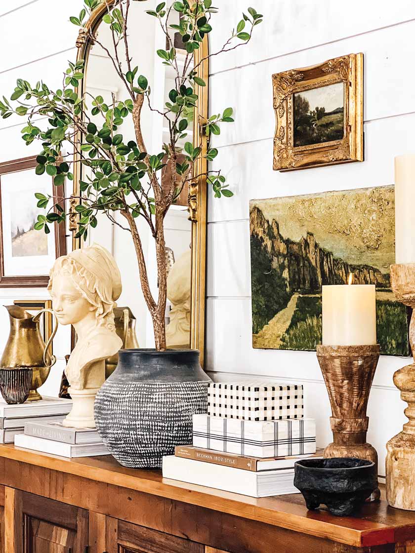 antique bust and art on dresser in home with white shiplap walls