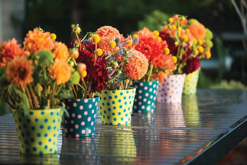blue thistle and marigold fall flower arrangement on outdoor dining table