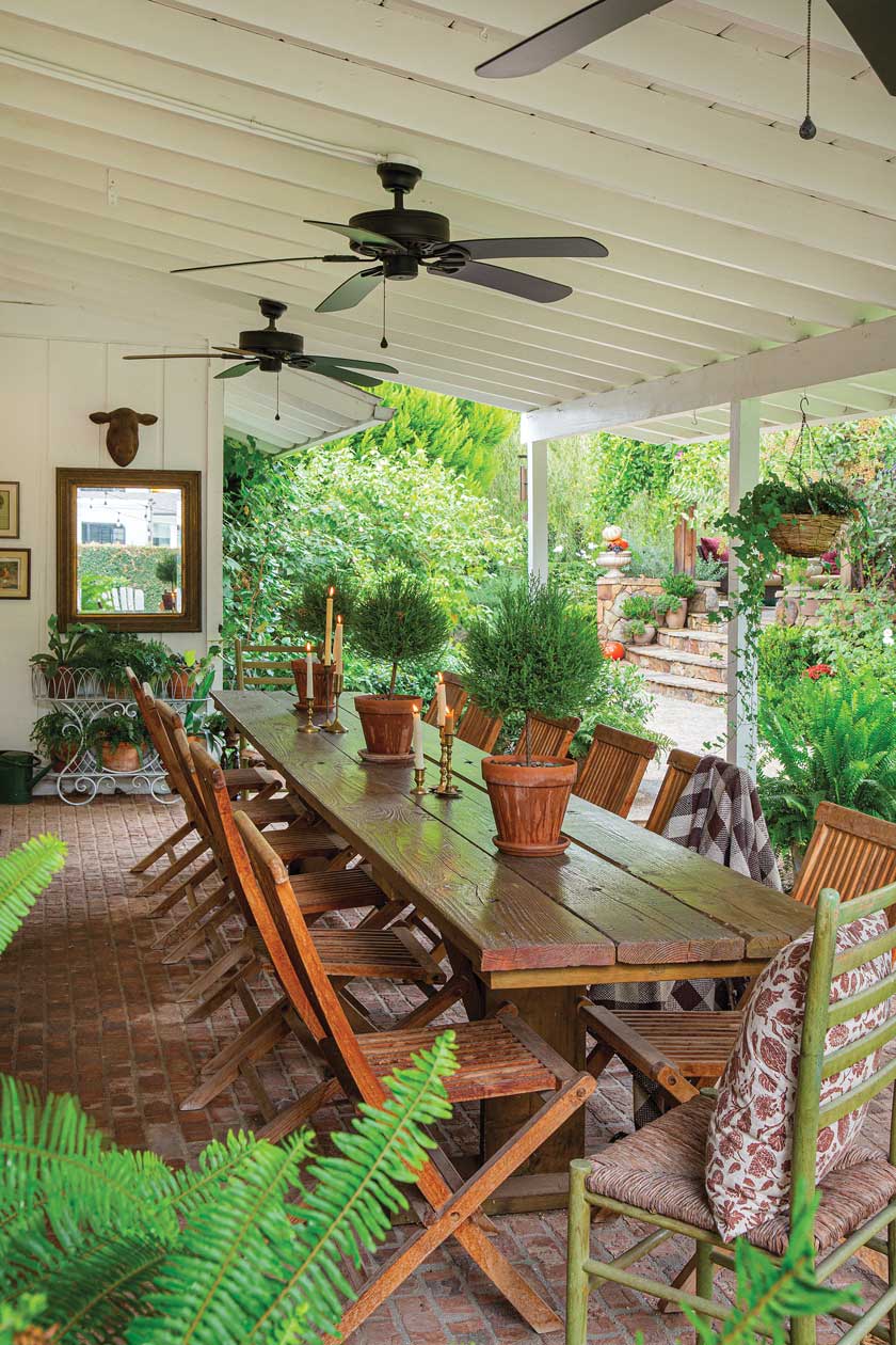 wooden dining table and ceiling fans on covered patio in renovated California home