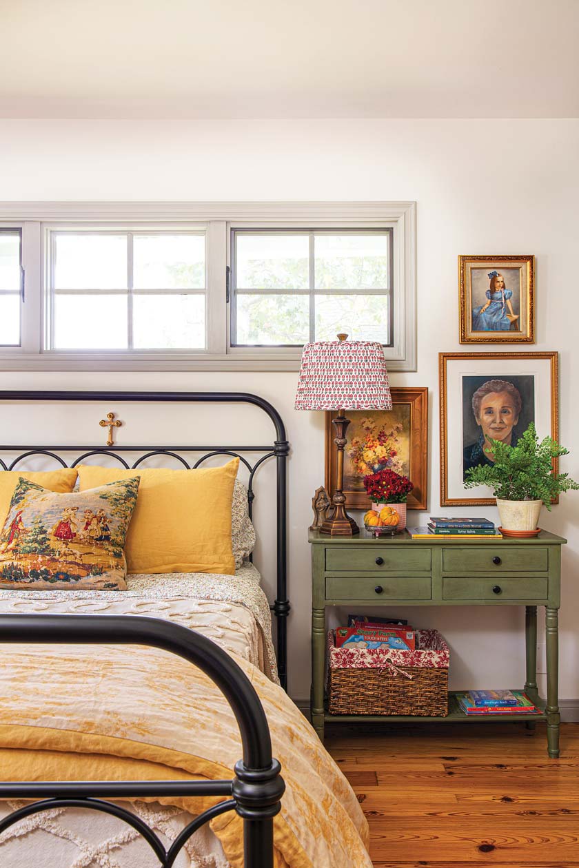 bedroom with iron bedframe and green nightstand and mini gallery wall
