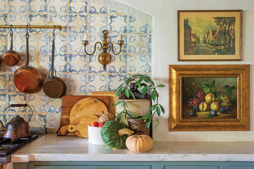 hanging bronze pots and pans and mosaic tile backsplash in renovated California home