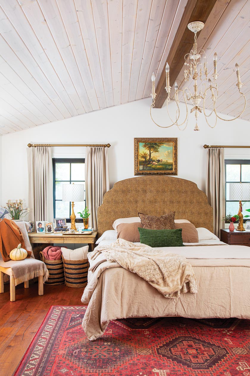 Old World chandelier and red rug in bedroom of maximum style cottage