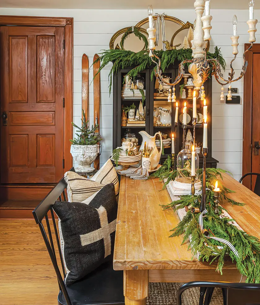 fresh greenery on farmhouse table and small potted tree in cozy holiday home
