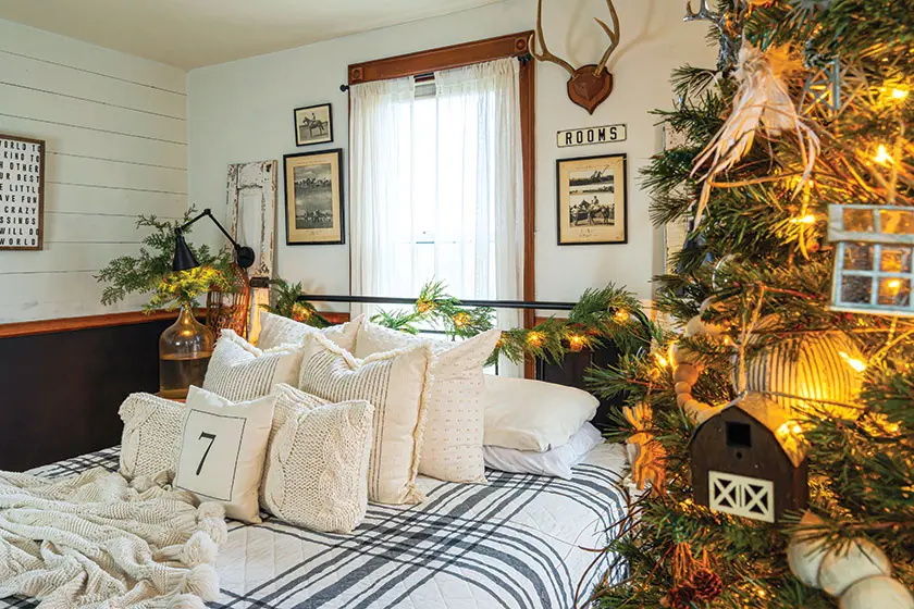 bedroom with tree and garland on bed frame