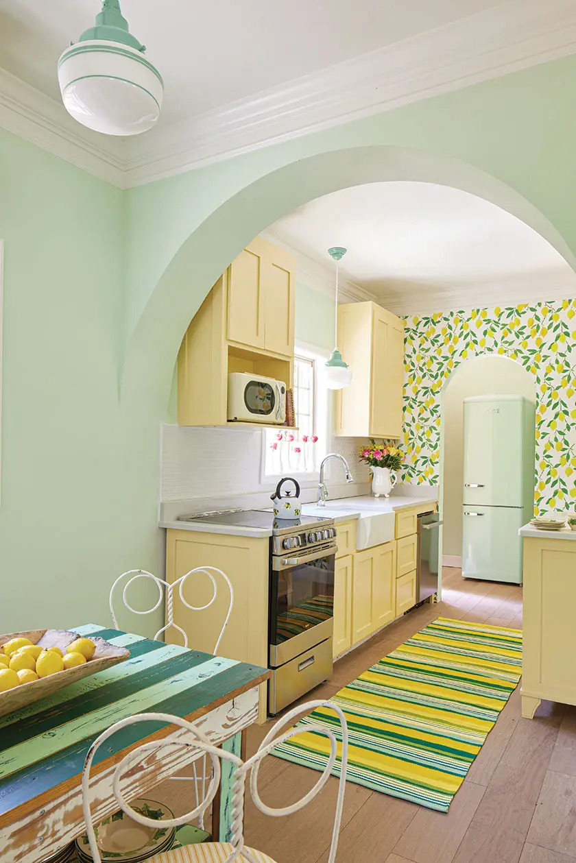 stripped teal and mint green dining table and yellow and green accents in restored kitchen