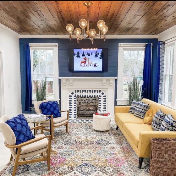 blue accents and yellow sofa in living room of Cottage on Fort