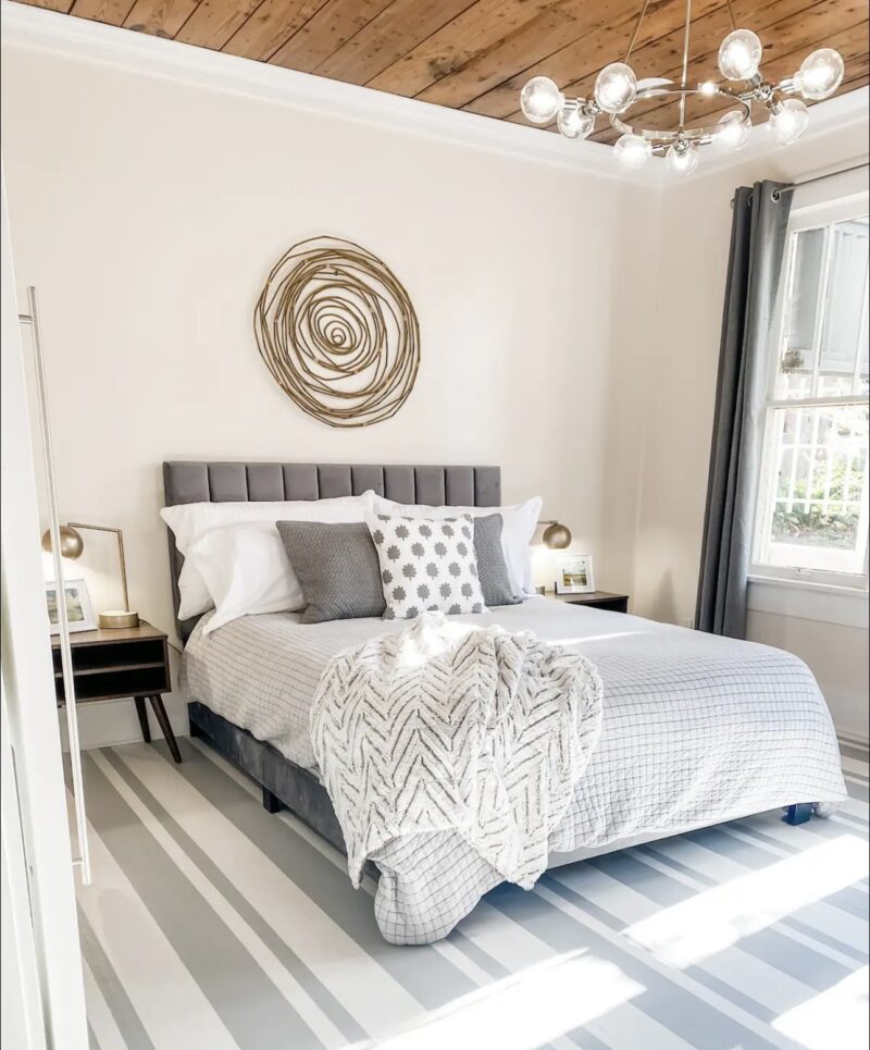 modern chandelier and circular woven wall art in bedroom of Cottage on Fort