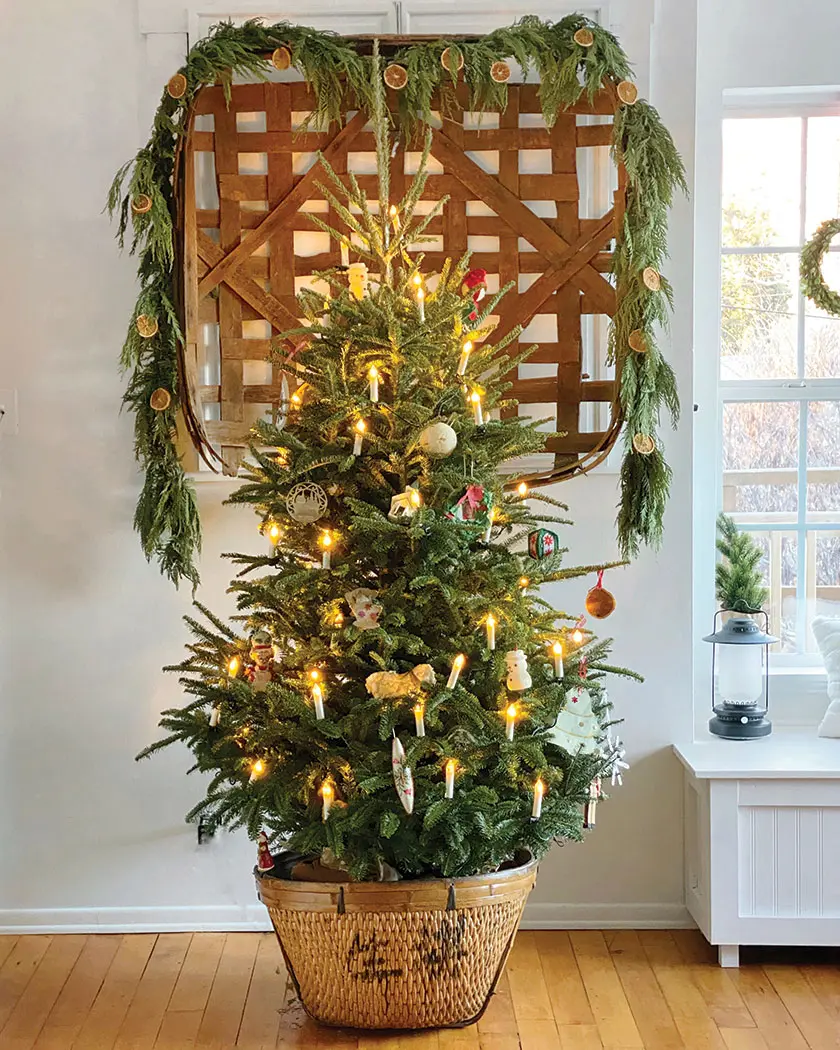 tree with heirloom ornaments and antique basket framed with cedar and orange garland