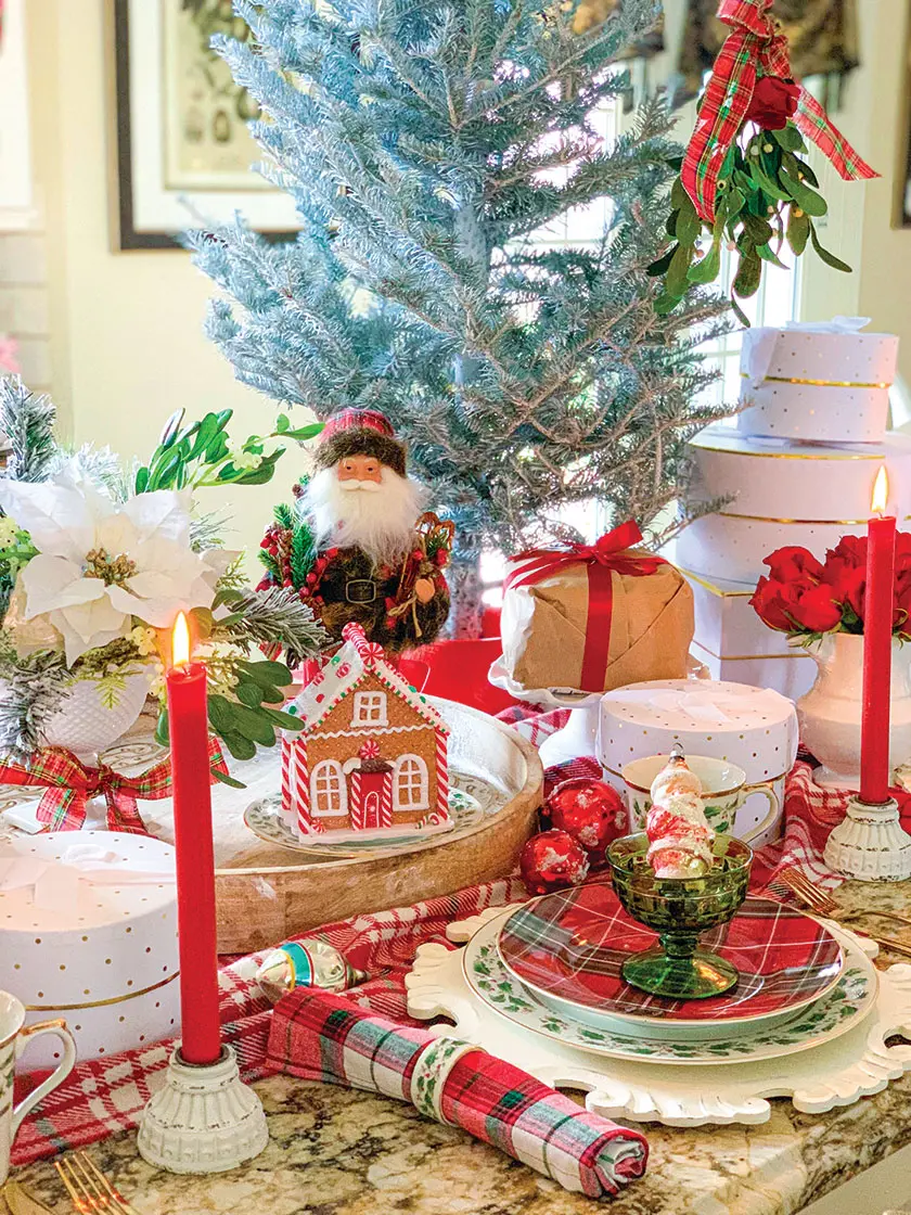 red plaid christmas tablescape with tapered candles and santa
