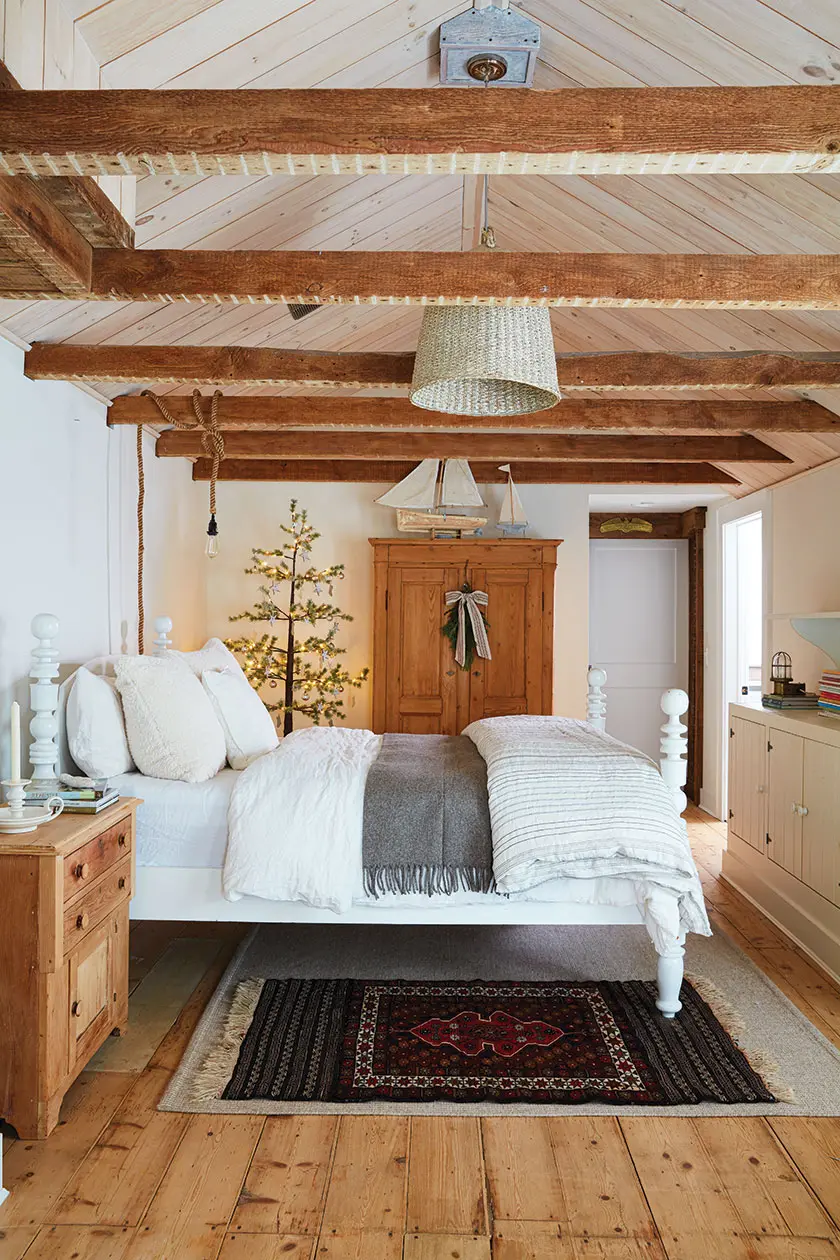 guest room with exposed wood beam and small Christmas tree