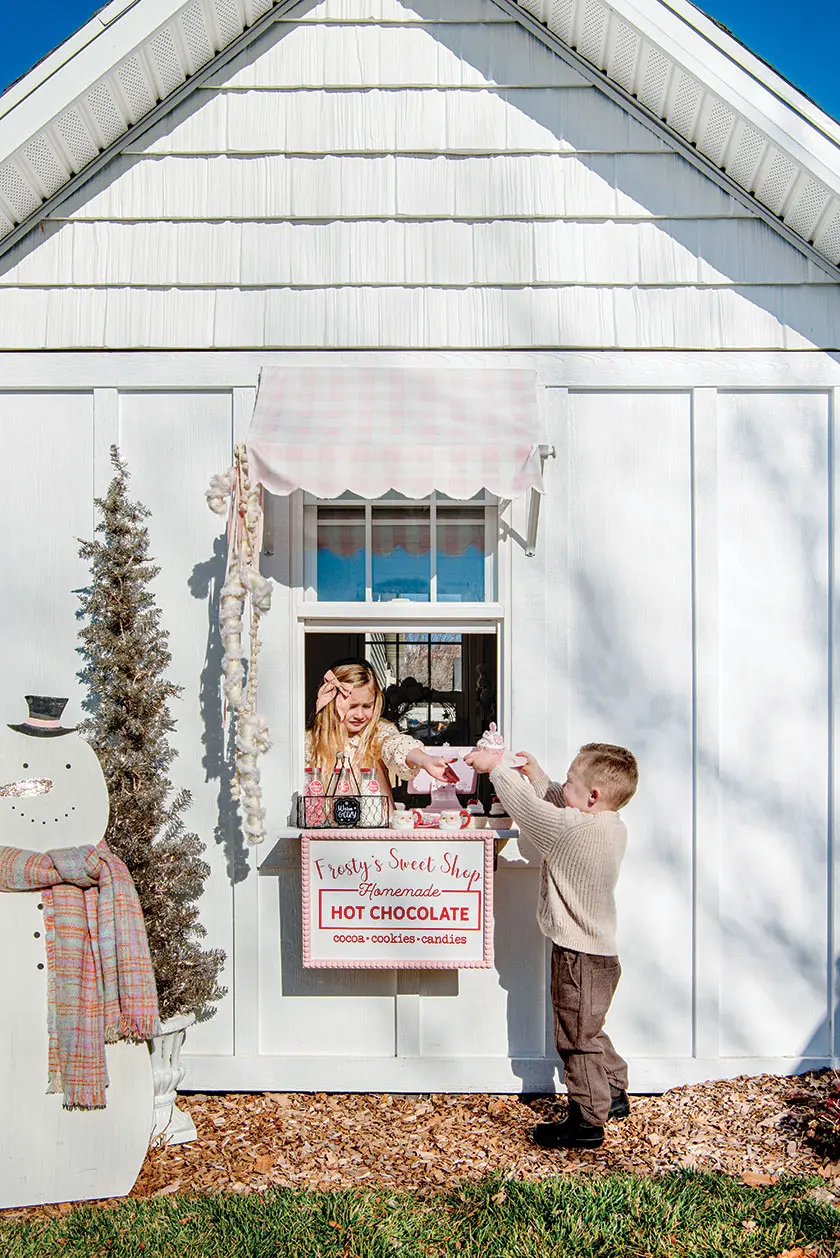 kids playhouse with festive hot chocolate sign and wood snowman