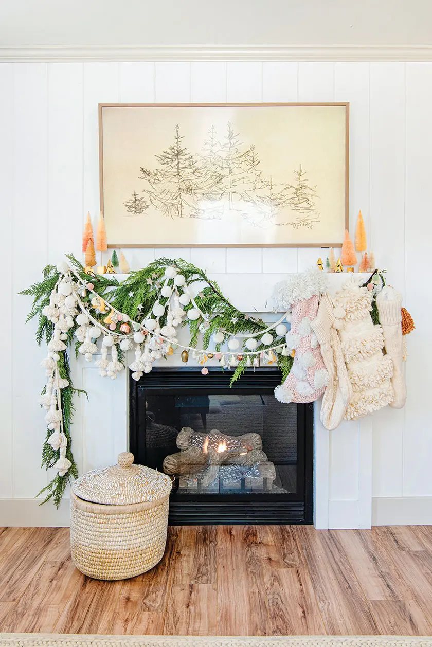 mantel decorated with cedar garland and layered with felt garlands and stockings