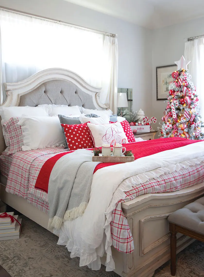red plaid duvet bedding and red and white ornaments on tree in bedroom