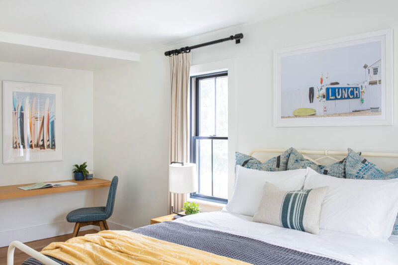 guest bedroom with custom wood desk and beach photos