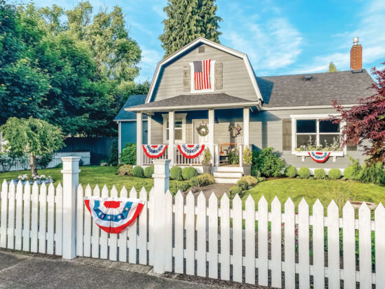 gambrel home with patriotic flags