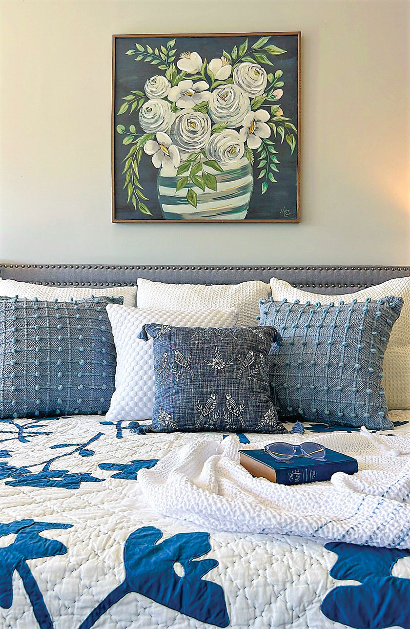 layered blue white and blue gray bedding in lakefront bedroom