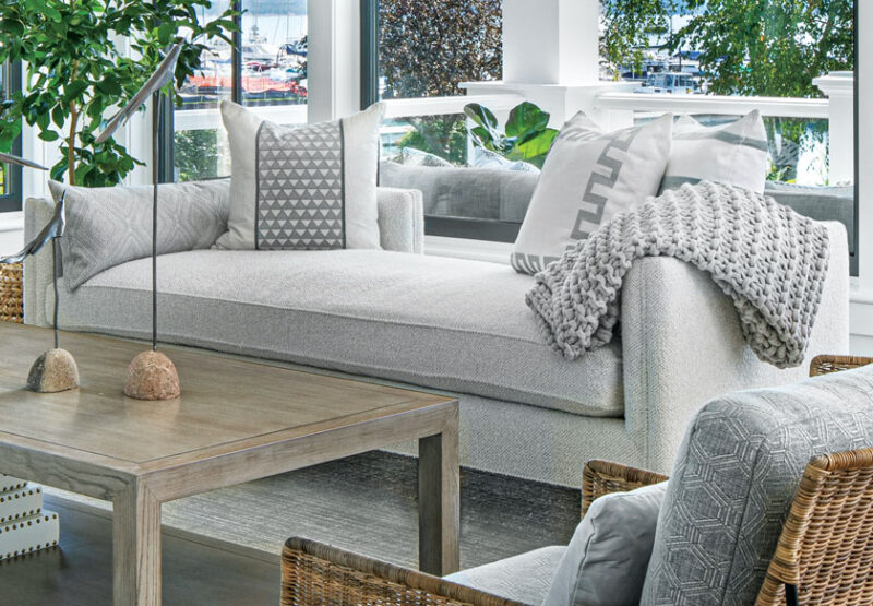 neutral living room with cable knit throw and geometric throw pillows