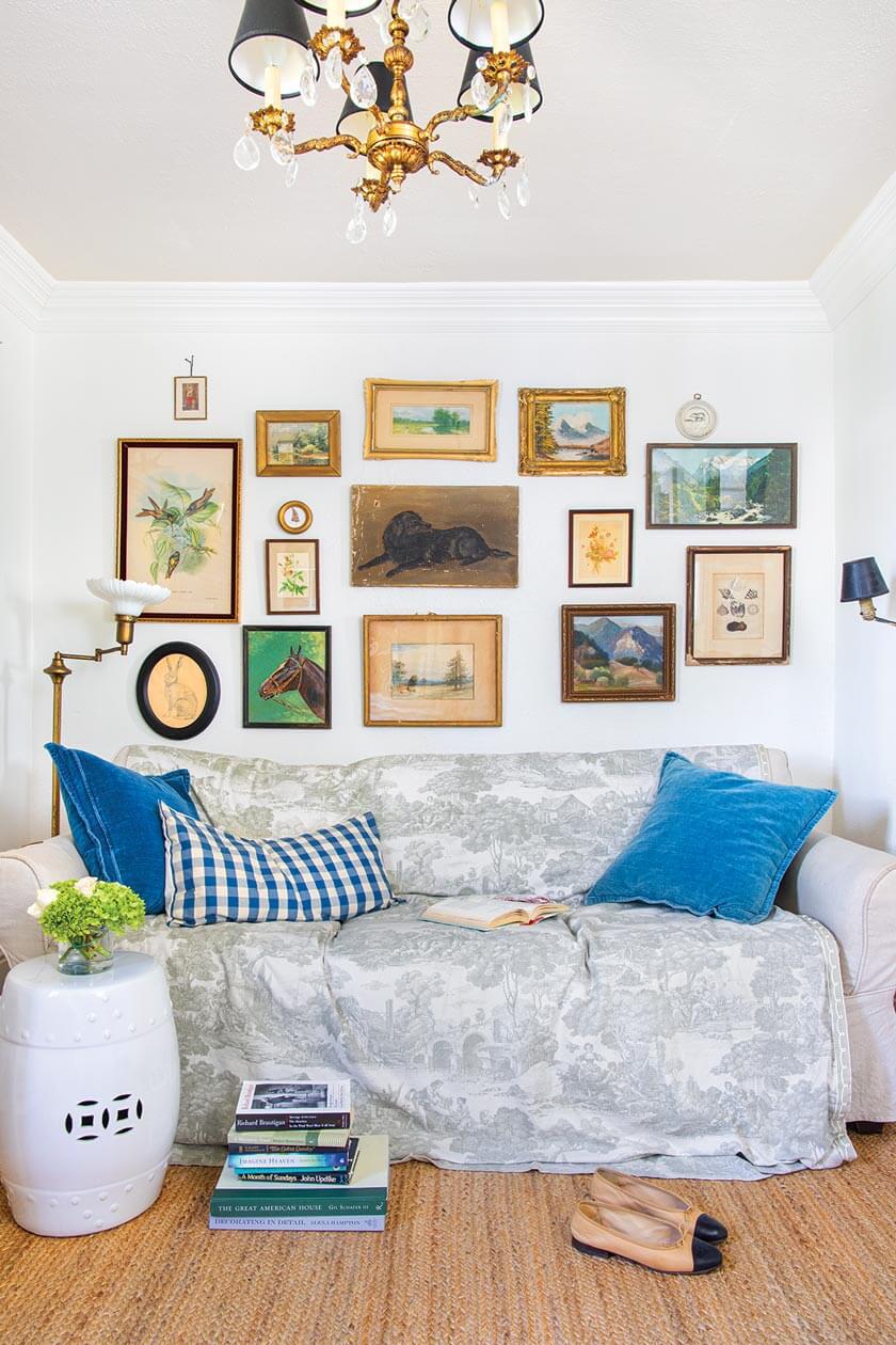 gallery wall with paintings and art prints in small cottage